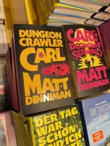 Buchcover in einer Buchhandlung: «Dungeon Crawler Carl» und «Carl’s Doomsday Scenario» von Matt Dinniman, farbenfrohe Titelgestaltung, umgeben von weiteren Büchern.